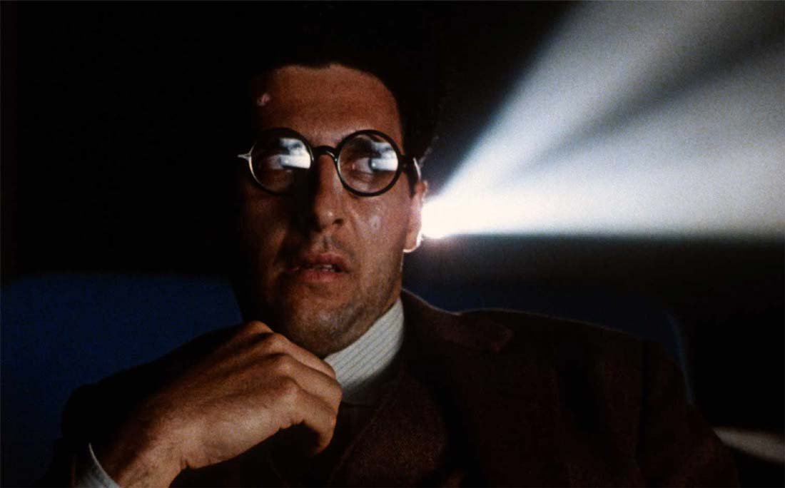 John Turturro sitter framför en projektor i "Barton Fink"