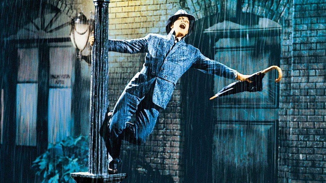 Gene Kelly snurrar runt en lyktstolpe en regnig afton i "Singin' in the Rain"