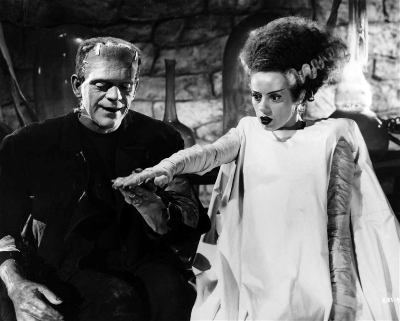 Ur Frankensteins brud. Monstret till vänster håller handen med den kvinnliga skapelsen som stirrar tomt ut framåt. 
