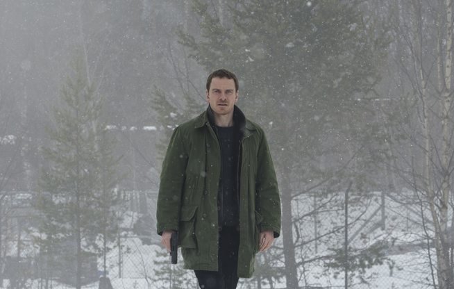 Michael Fassbender håller i en pistol i filmen Snömannen