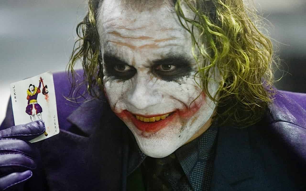Heath Ledger som Jokern i The Dark Knight från 2008 där han håller kortet Jokern i handen.