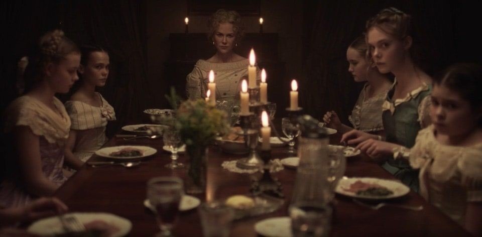 Medverkande i filmen "De bedragna" sitter vid ett middagsbord