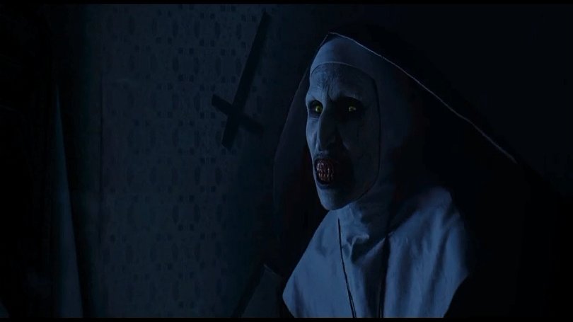 Nunnan, känd från Conjuring, får nu egen film. På bilden syns nunnan till höger, till vänster om henne syns en vägg med ett upp-och-nedvänt kort. 