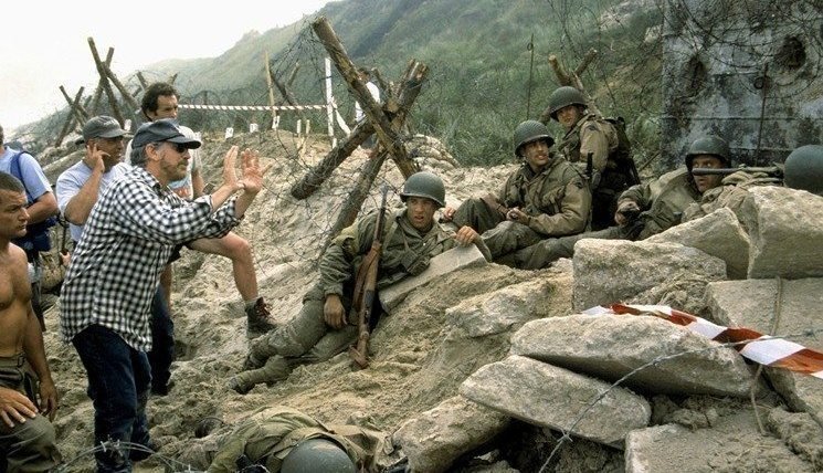 Steven Spielberg förklarar något för resten av gruppen under inspelningen av Normandie-scenen i "Rädda menige Ryan". 