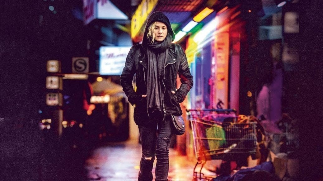 Diane Kruger går längs en regnig och neonklädd gata i Utan nåd.