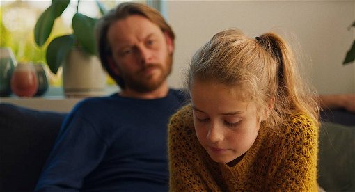 Bild från den norska filmen Barn föreställandes flickan Lykke i förgrunden och läraren Anders i bakgrunden. 