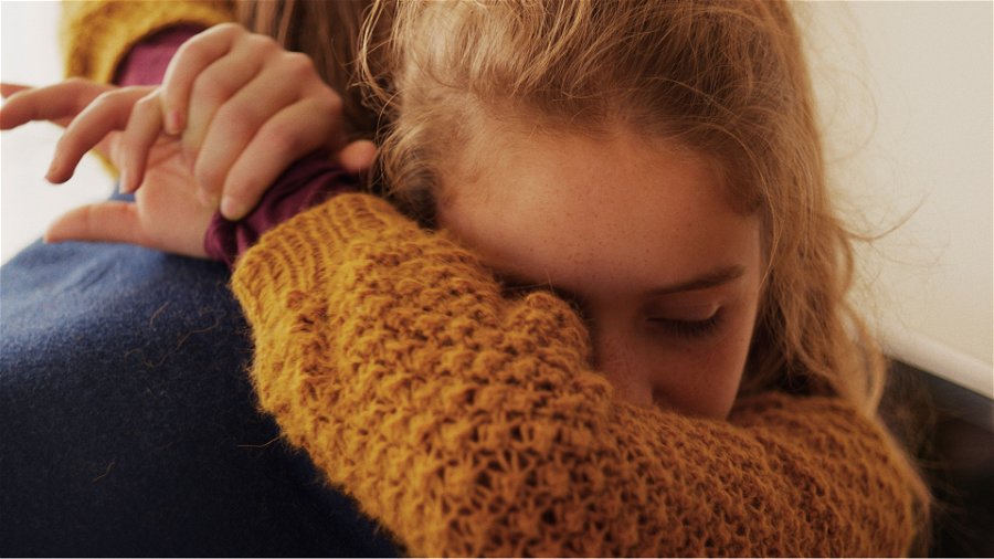 Bild från den norska filmen Barn föreställandes en flickan Lykke kramades läraren Anders. 