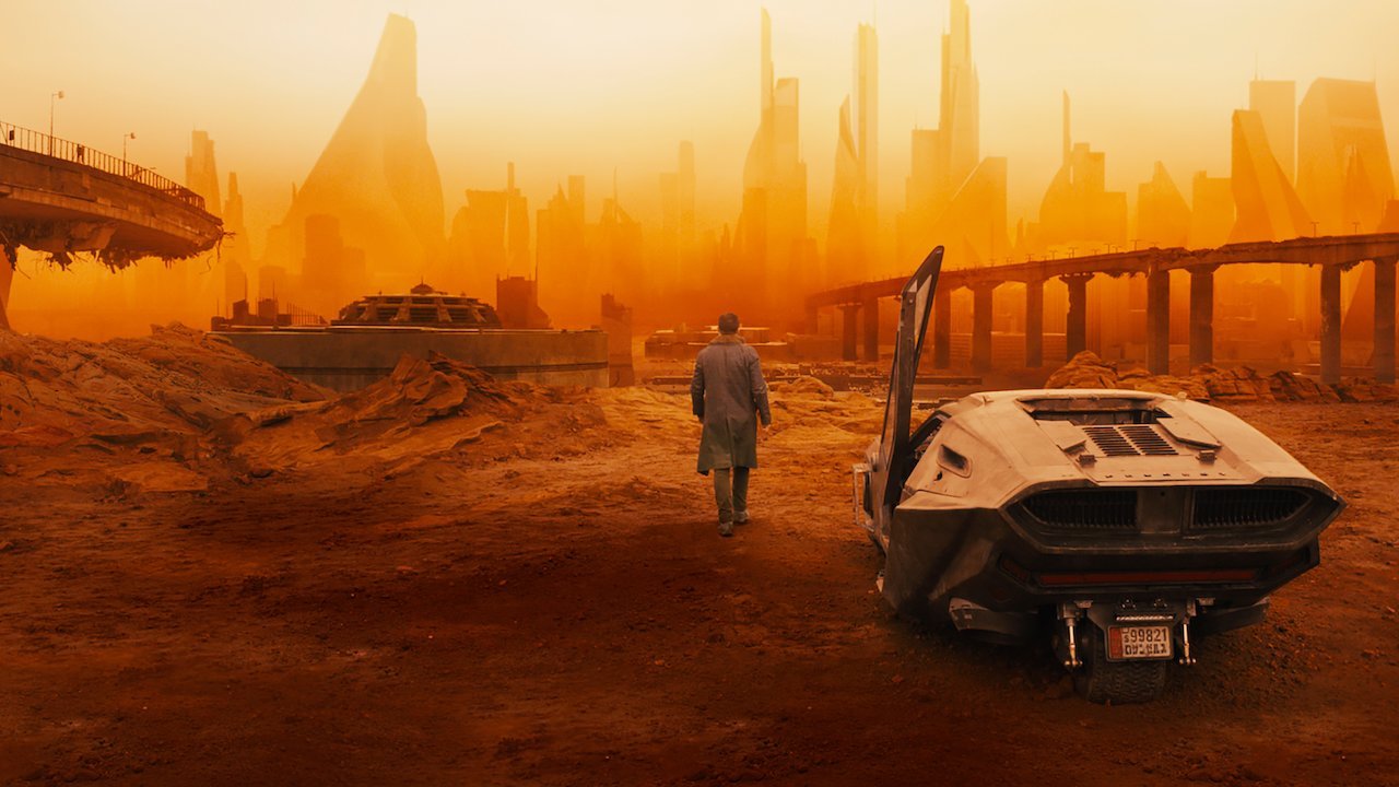 En blade runner och hans bil i ett ökenlandskap i Blade Runner 2049.