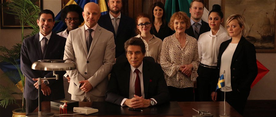En bild på rollbesättningen i Viaplay-serien Ambassadören, med Mikael Tornvig i mitten. 