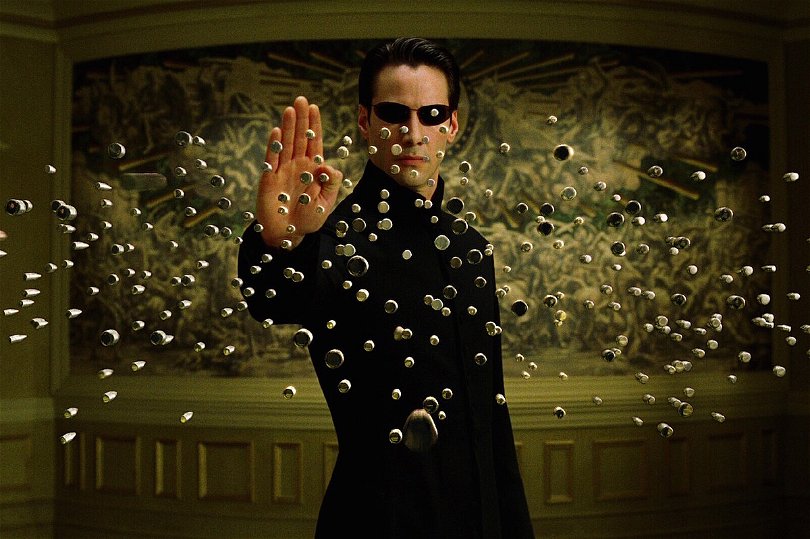 Neo (Keanu Reeves) kan stoppa kulor genom att vifta med handen. Realistiskt? Nej. Coolt? Ja. Foto: Warner Bros. Pictures.