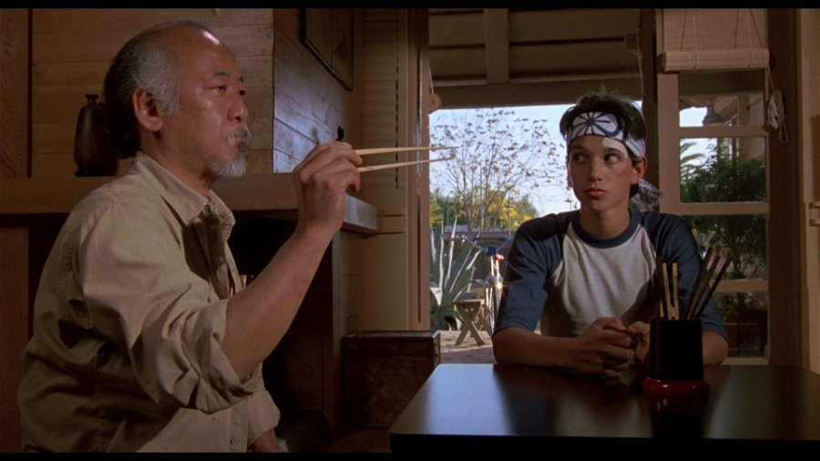 Bild på Pat Morita som Mr.Miyagi och Ralph Macchio som Daniel i Karate Kid. 