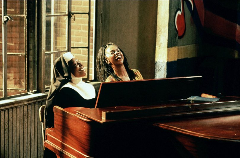 Två damer sjunger bakom ett piano