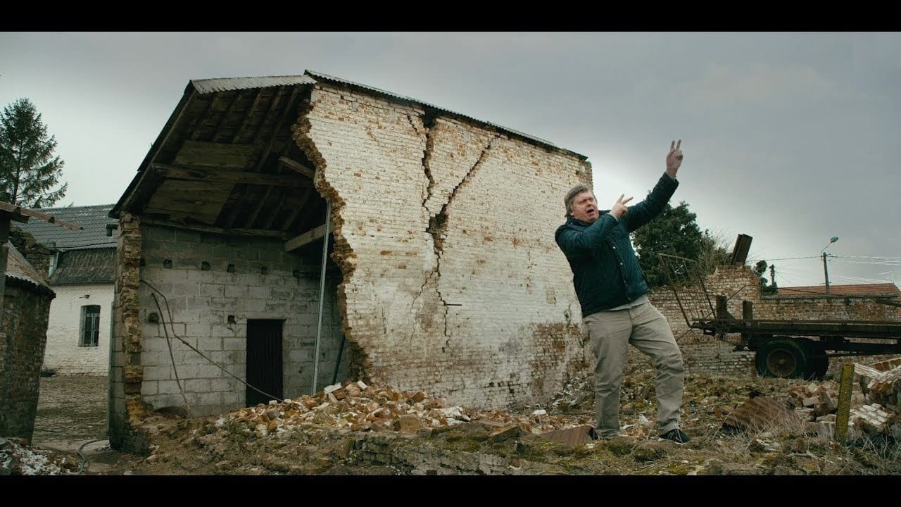 Bild på Patrick Betit från filmen Excess Will Save Us. Han står med händerna i skyn och låtsats avfyra ett gevär. 